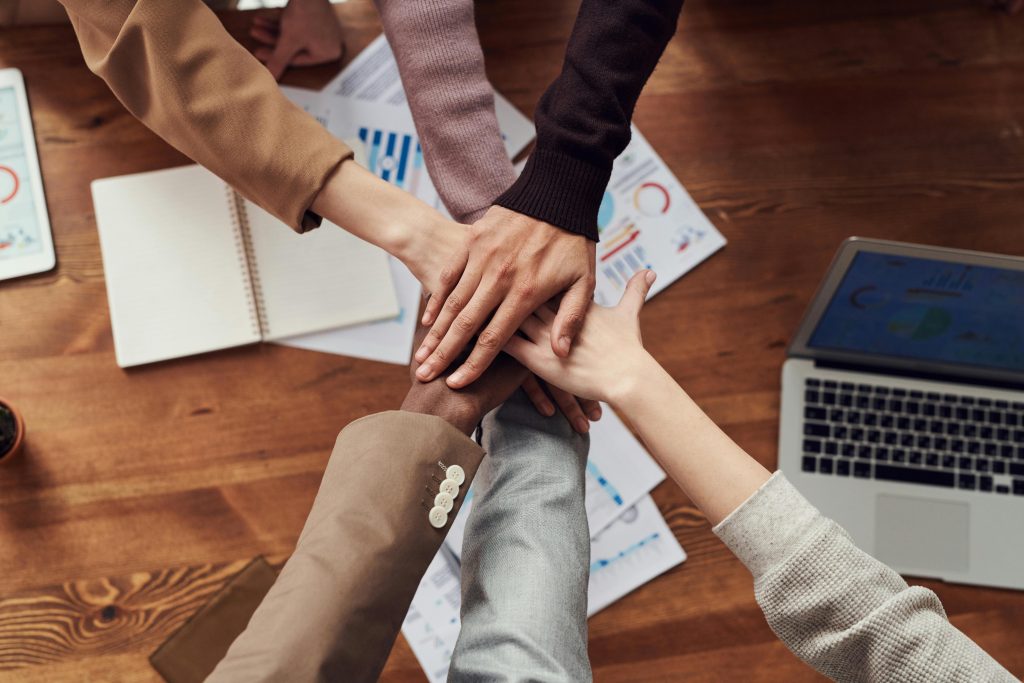 Six people in a group putting their hands together