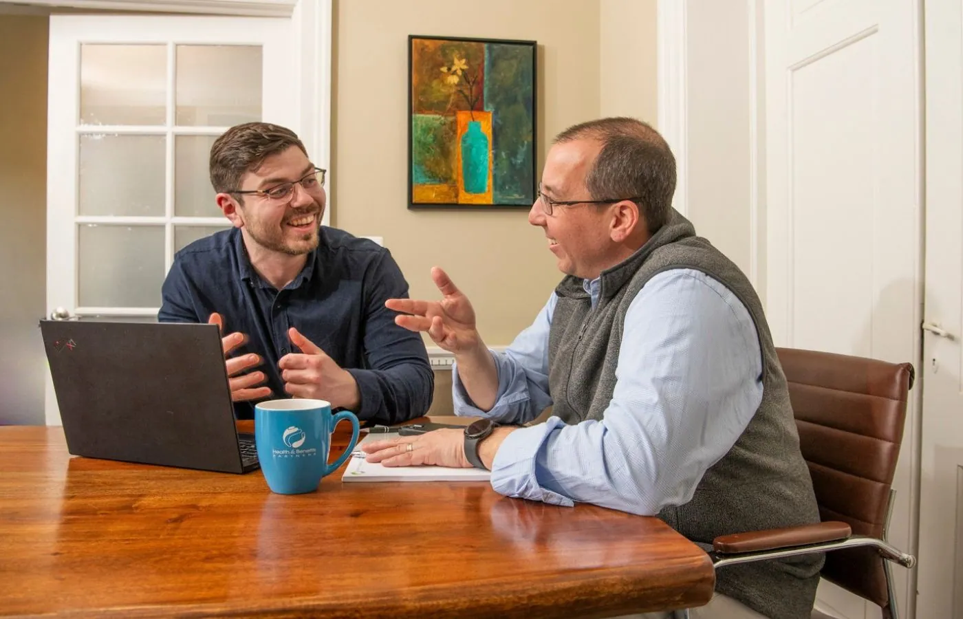 Advisor reviewing workers compensation and benefits paperwork with a small business client